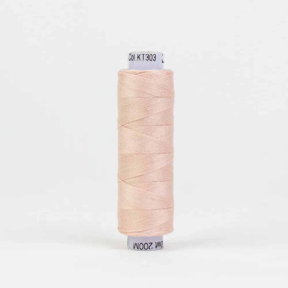 Spool of baby pink sewing thread, neatly wound on a cardboard core