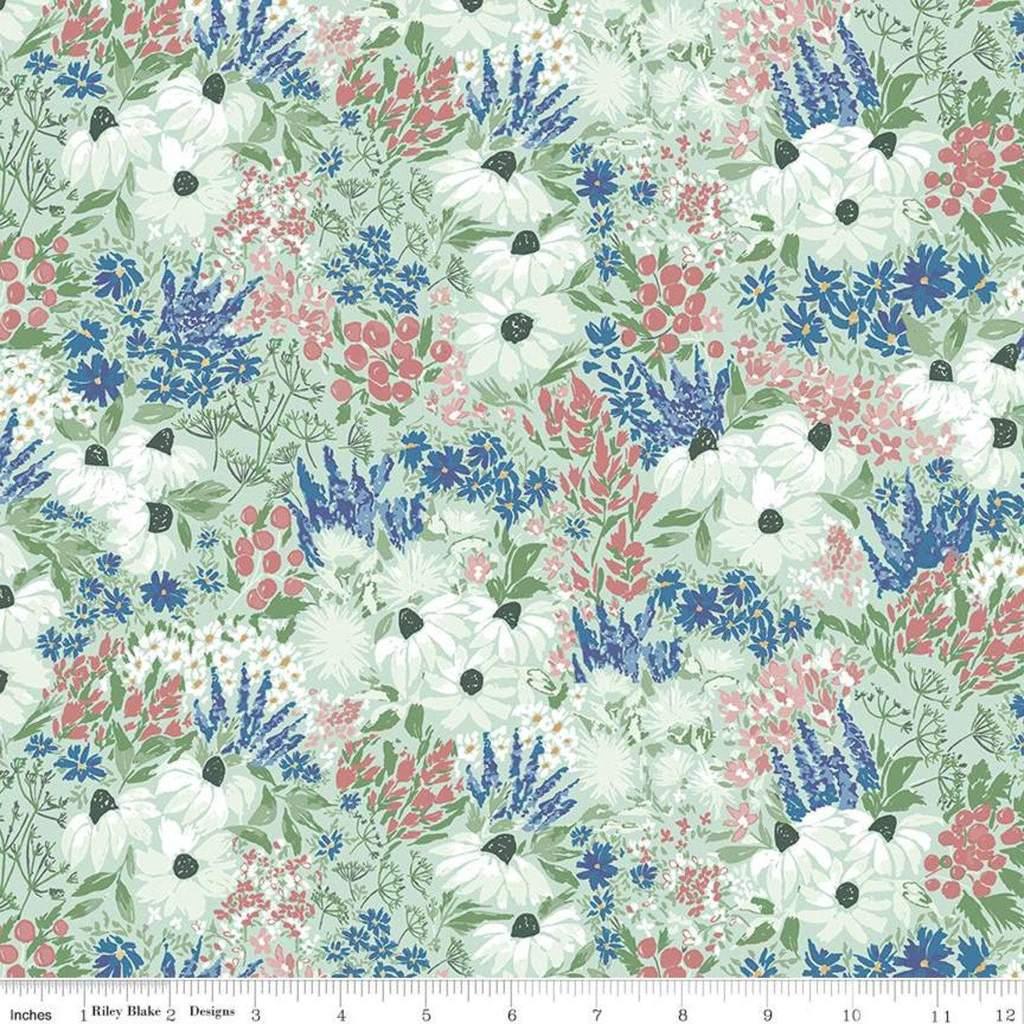 Floral fabric with blue wildflowers, white blossoms, red berries, and green leaves