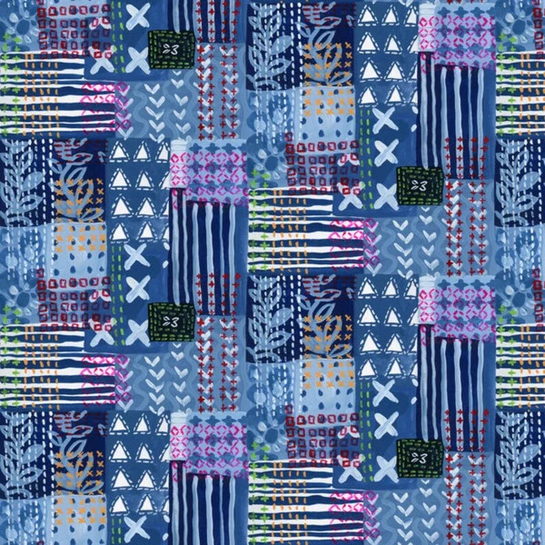 Patchwork fabric with blue, pink, and multicolor geometric blocks and stripes