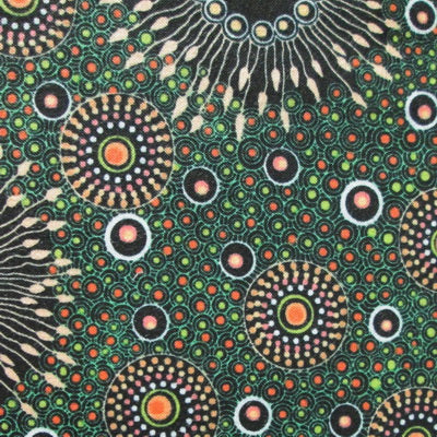 Green fabric with circular motifs in black, orange, and cream dots