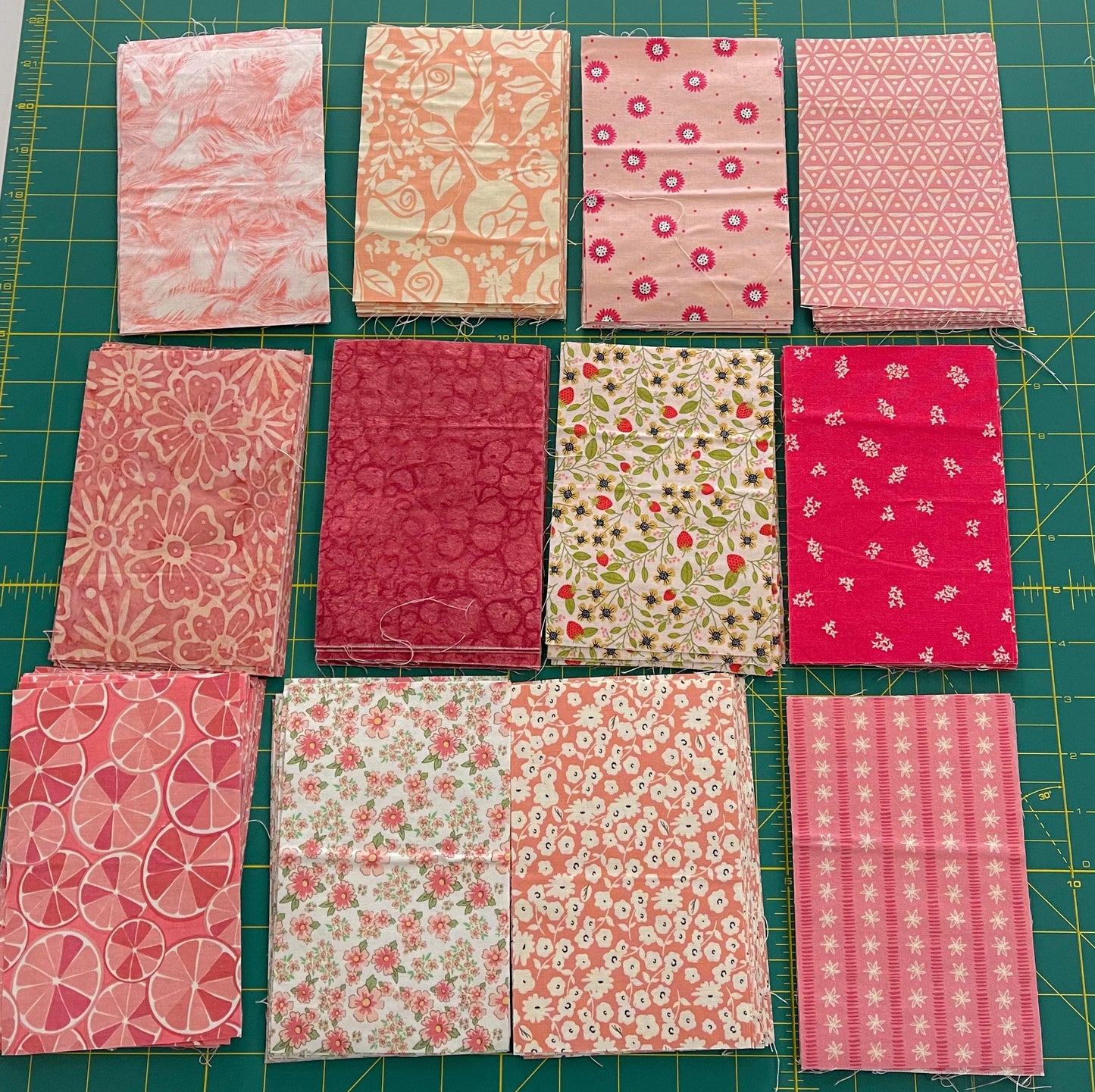 Assorted pink fabric squares bundle with floral and geometric prints