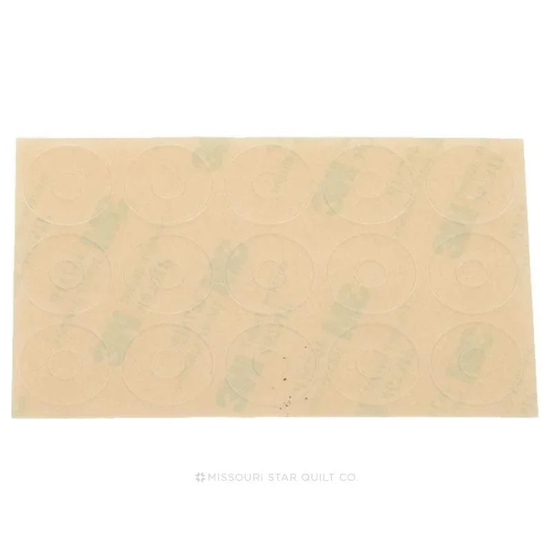Beige non-slip adhesive ring dots on a backing sheet