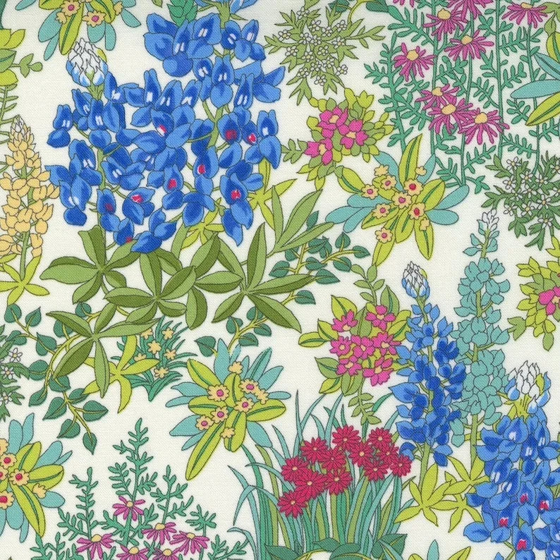 Floral quilting fabric with multicolor wildflowers and leaves on light ground