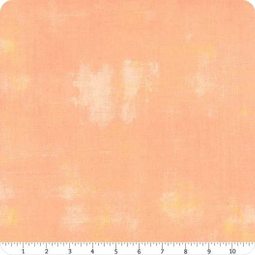Peach grunge-textured cotton fabric yardage with subtle distressed pattern