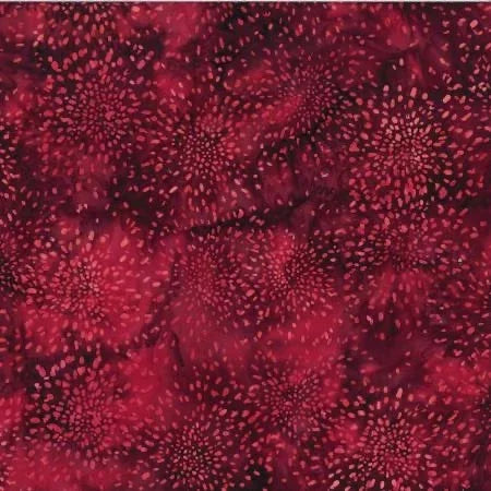 Batik cotton fabric in dark red with scattered small dot pattern and circular accents