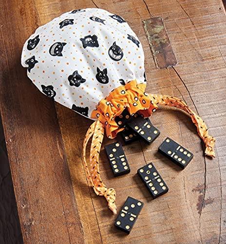 Fabric pouch with black-spotted print and orange lining beside domino tiles