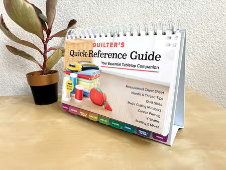 Quilter's quick-reference guide book with colorful quilting tools on cover