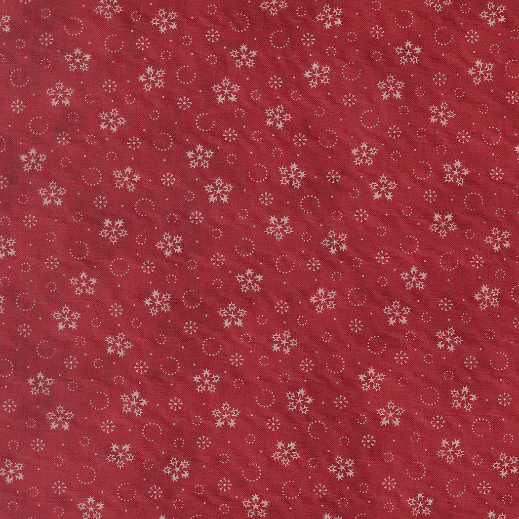 Crimson cotton fabric with scattered snowflakes and small dotted circles pattern