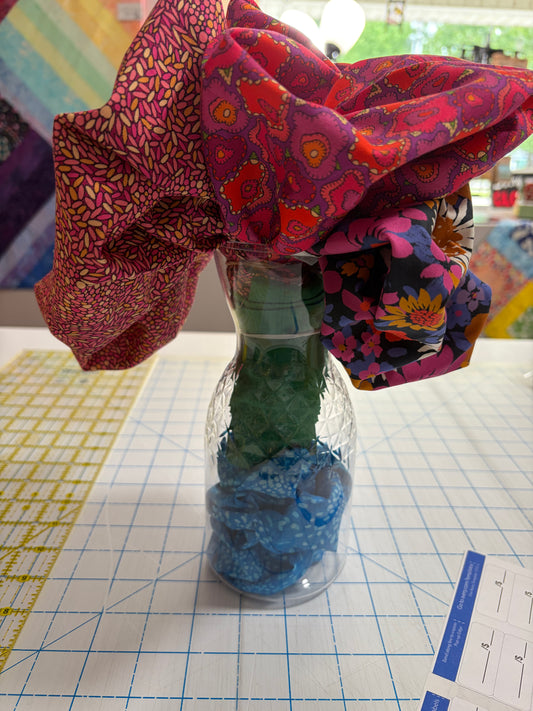 Colorful fabric flower arrangement with multicolor fabric in a clear glass vase
