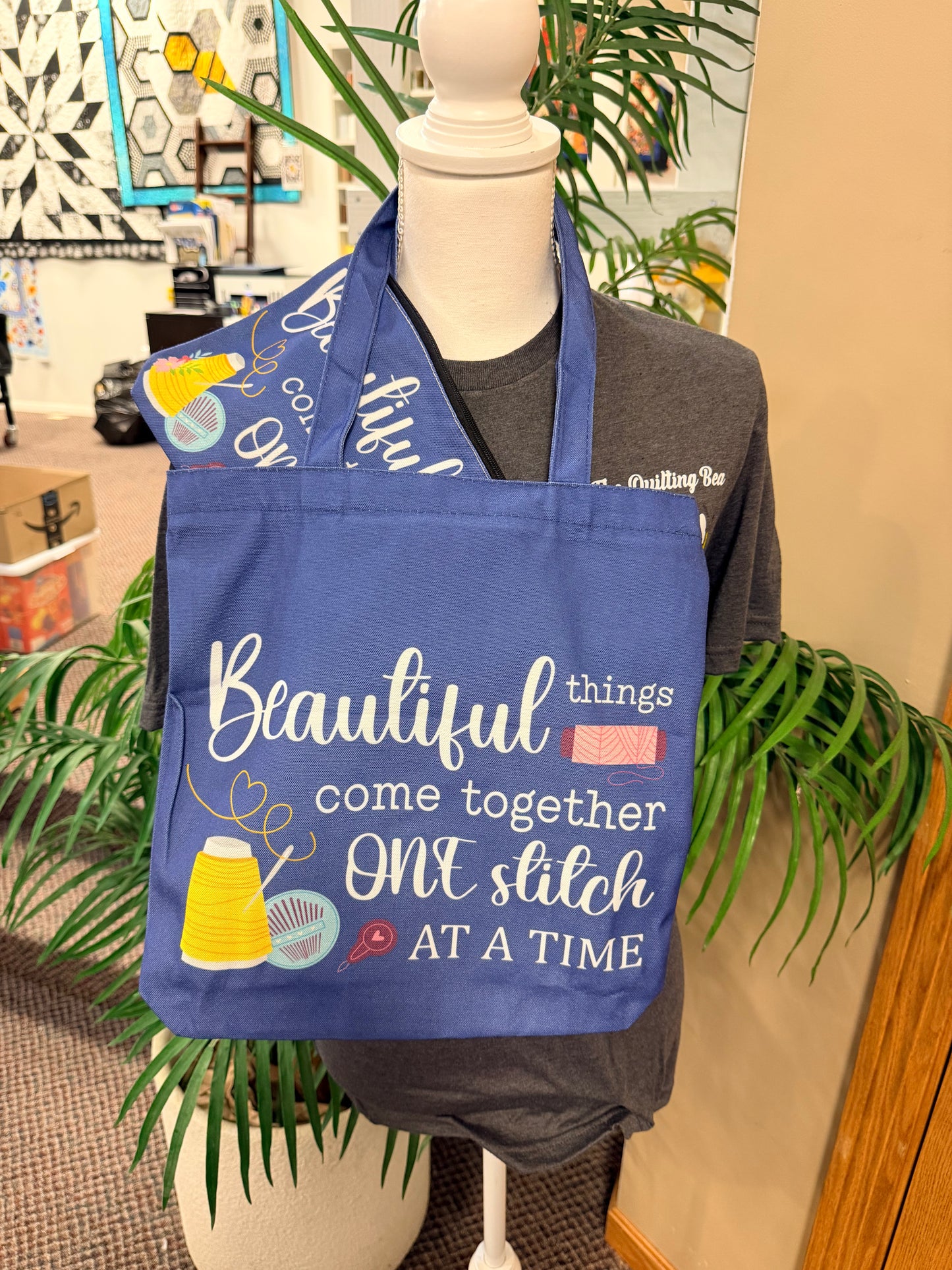Blue canvas tote bag with "Beautiful things" "one stitch at a time" text