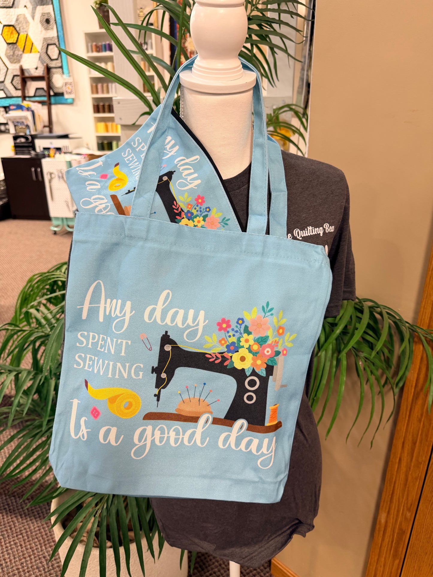 Light blue canvas tote bag with "Any day spent sewing is a good day" quote