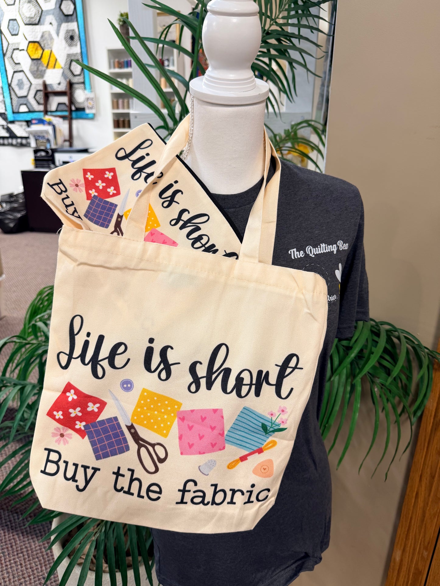Cream canvas tote bag with "Life is short" "Buy the fabric" sewing print