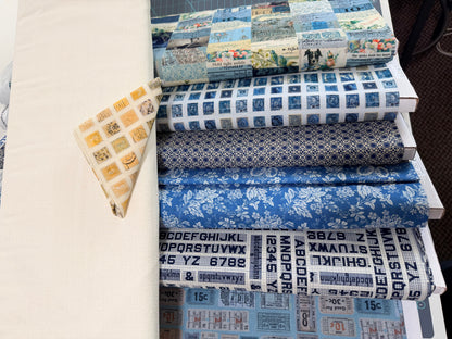 Patchwork fabric bundle with blue printed rolls and a yellow grid-pattern triangle