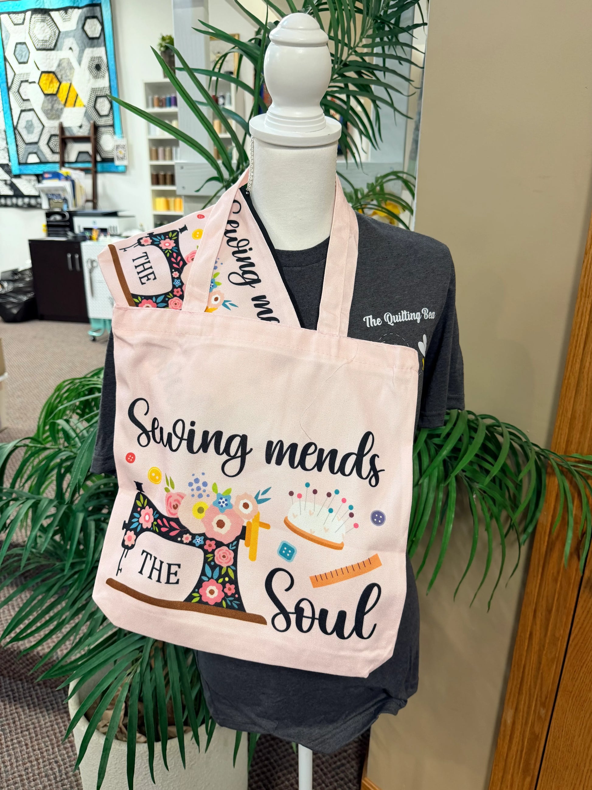 Light pink canvas tote bag with "Sewing mends the soul" sewing-themed artwork