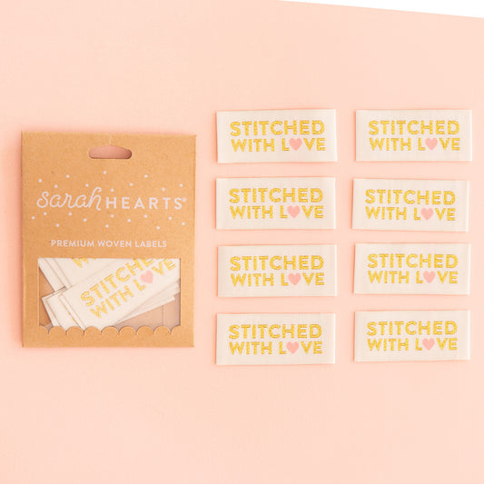 Gold woven labels set with "Stitched With Love" text, brand cards included