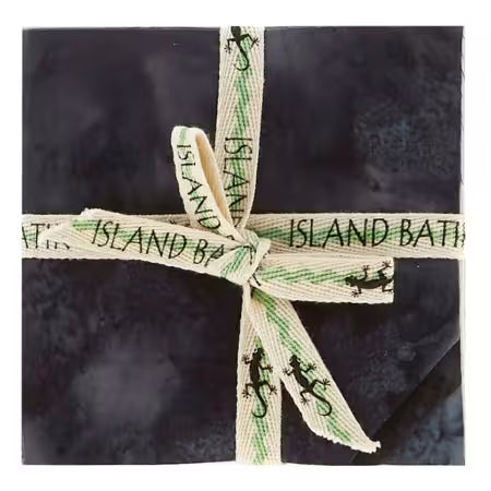 5-inch charm pack of black batik fabric squares, tied with green ribbon