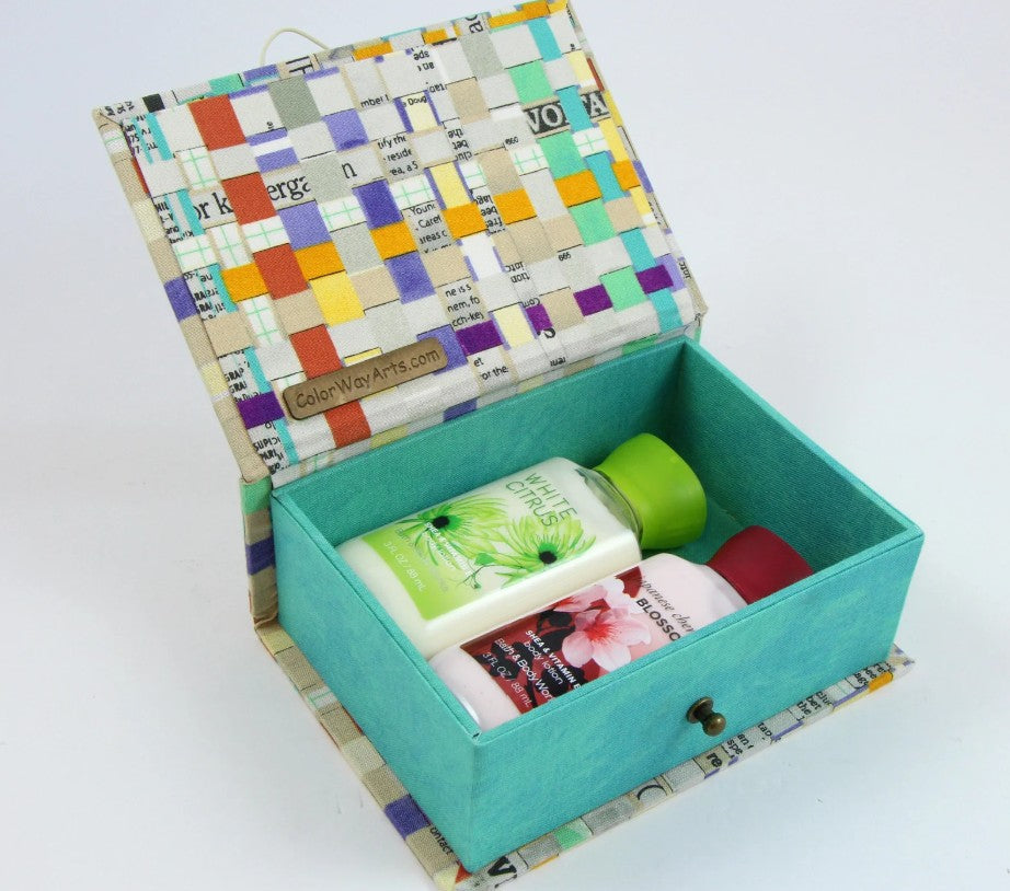 Small fabric box with hinged lid, open turquoise interior holding craft supplies