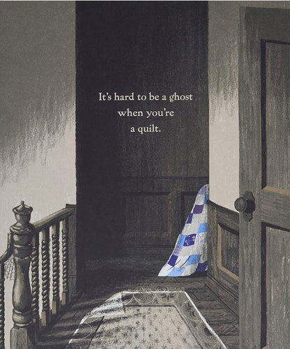 Blue-and-white patchwork ghost quilt draped on floor, hood pointing down.